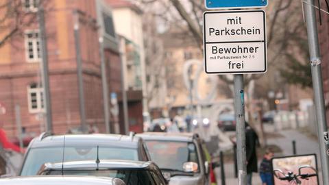Foto von parkende Autos in einer Straße und im Fokus ein Schild mit der Aufschrift "Mit Parkschein - Bewohner frei".