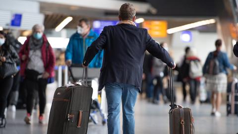 Ein Passagier läuft mit seinem Gepäck am Flughafen Frankfurt. 