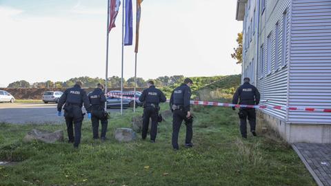 Polizisten suchen das Gelände nach der Tatwaffe ab