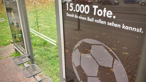 Protestplakat gegen Fußball-WM hängt an Haltestelle in Frankfurt