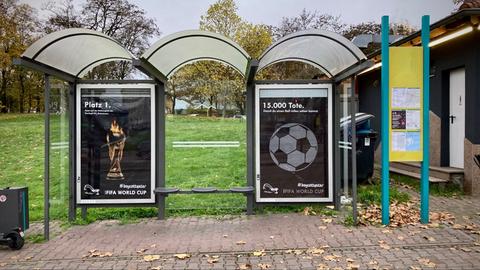 Protestplakat gegen Fußball-WM hängt an Haltestelle in Frankfurt