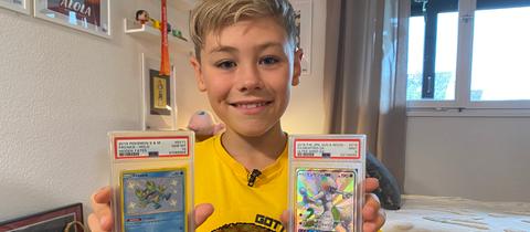 Alexander Krol hält in seinem Kinderzimmer Pokémon-Karten in die Kamera