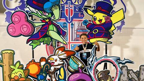 Alexander Krol bei der Pokémon-Meisterschaft in London in einer bunten Kulisse mit Pokémon-Figuren