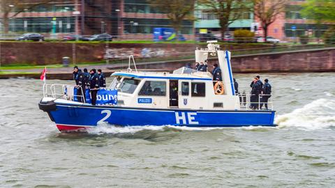 Streifenboot HE 2 der Wasserschutzpolizei Frankfurt bei einer Übung auf dem Main  - auf dem Boot stehen an Bug und Heck mehrere Polizisten in Uniform. 