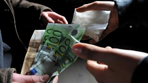 Geldscheine werden im Tausch gegen ein Drogentütchen übergeben