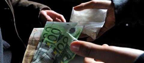Geldscheine werden im Tausch gegen ein Drogentütchen übergeben