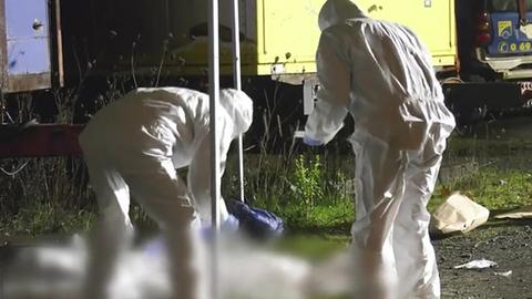 Spurensicherer der Polizei in weißen Anzügen untersuchen den Tatort in Frankfurt-Praunheim, wo ein Mann erschossen wurde