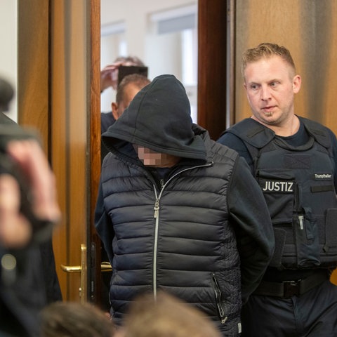Der 62 Jahre alte Angeklagte (Mitte) wird in den Gerichtssaal in Darmstadt geführt.