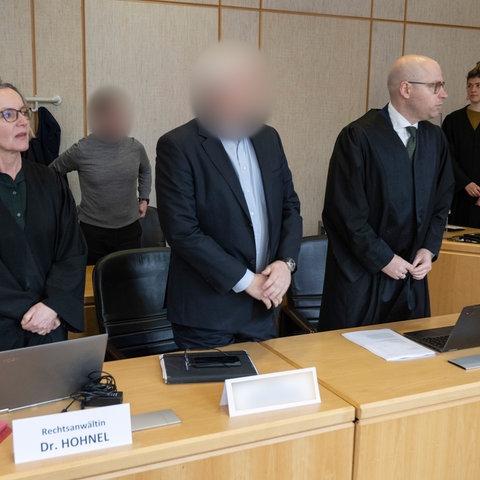 Prozesstag vor dem Landgericht Frankfurt. Der der angeklagte Ex-Oberstaatsanwalt Alexander B. und seine Verteidiger, die links und rechts von ihm stehen. 