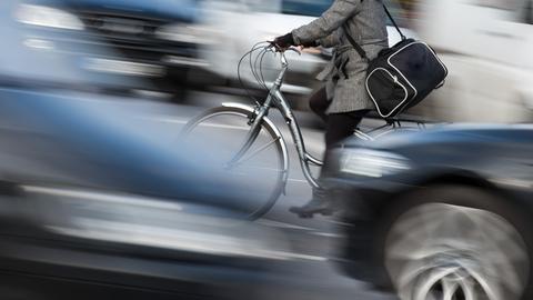 Radfahrerin mit Tasche im Straßenverkehr