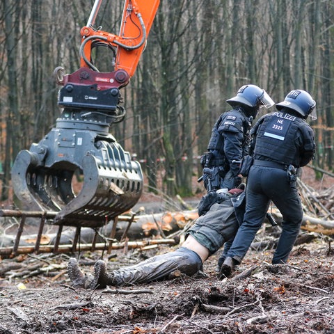 Polizisten schleifen einen Aktivisten im Dannenröder Forst weg.