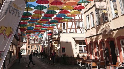 Bunte Regenschirme schweben in der Luft.