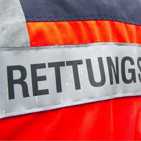 Rückseite einer "Rettungsdienst"-Jacke, die von einer Person getragen wird.