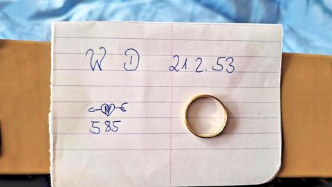 Goldener Ring liegt auf einem linierten Blatt, auf dem "W D 21.2.53" und "585" in Handschrift geschrieben steht.