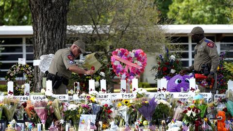Polizeibeamte legen Blumen vor der Robb Elementary School in der Stadt Uvalde, Texas, USA, nieder. 