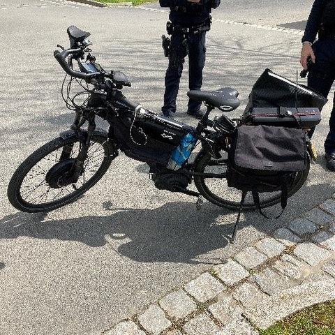 Ein schwarzes Fahrrad mit Elektromotor und Satteltaschen
