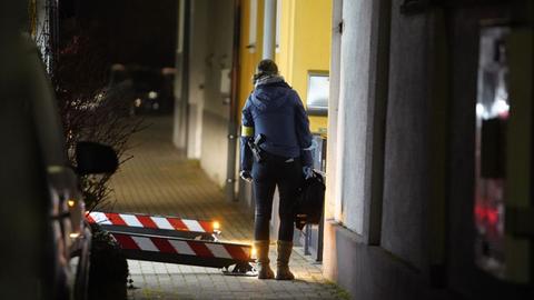 Ermittler untersuchen das Haus, in dem ein Mieter Einschusslöcher entdeckt hat - die von seinem Nachbarn stammen sollen.