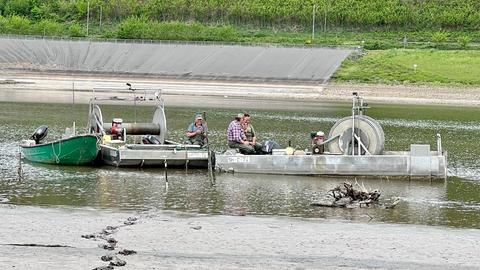 Boote mit Männern auf einer Wasserfläche.