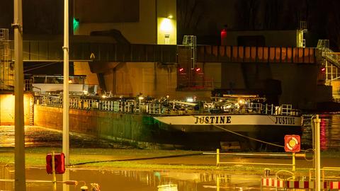 Ein Schiff mit der Aufschrift "Justine" im Dunkeln an einer Schleusenanlage.