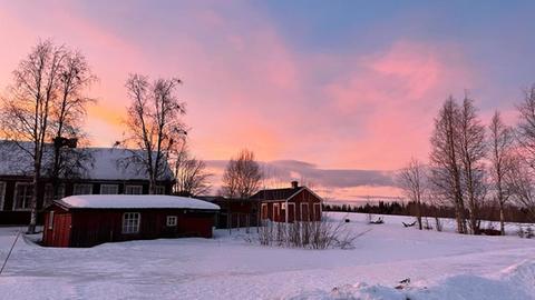 Ein Haus vor dem Sonnenuntergang in Lappland, der Himmel ist rot
