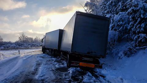 Ein Lkw steht leicht quer auf einer schneebedeckten Auffahrt zur A3