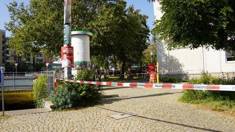 Ein Platz in einer Innenstadt ist mit einem rot-weißem Band abgesperrt.