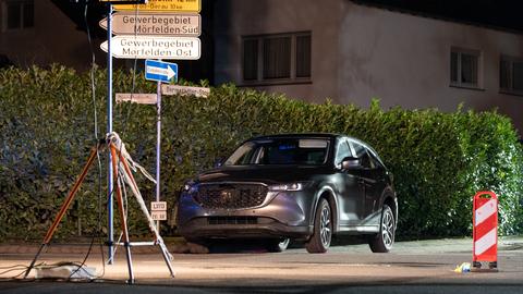 Eine Auto, auf das mutmaßlich geschossen wurde, steht auf einer Straße, davor Absperrungen.