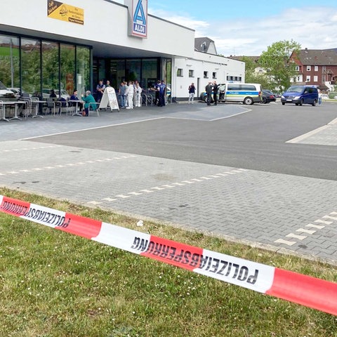 Absperrband riegelt den Parkplatz des Supermarkts ab.