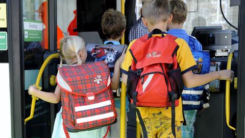 Kinder steigen in einen Schulbus