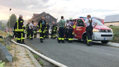 Viele Feuerwehrleute auf einer Straße neben der Schule.