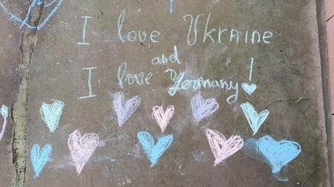 "I love Ukraine & I love Germany" steht mit bunter Kreide geschrieben auf einer Mauer.