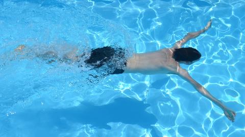 Junge taucht mit ausgebreiteten Armen im Wasser