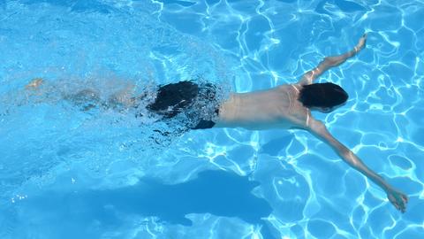 Junge taucht mit ausgebreiteten Armen im Wasser