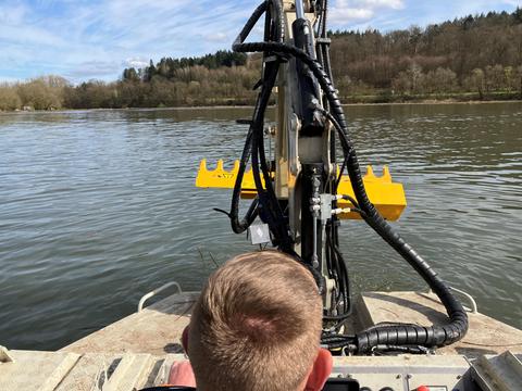 An einem Kran ist eine Art überdimensionierte Heckenschere befestigt, mit der junge Weiden unterhalb der Wasserlinie abgemäht werden können. 