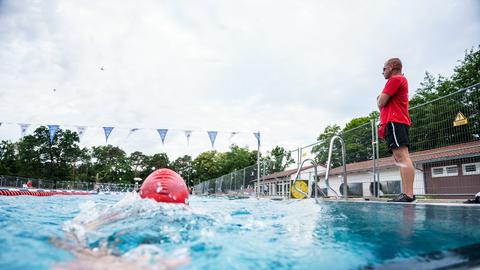 Ein Mitarbeiter vom Waldschwimmbad Rosenhöhe in Offenbach beobachtet das Geschehen im Freibad.