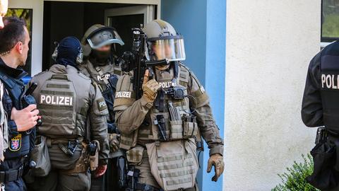 Polizisten durchsuchen eine Wohnung in Bergen-Enkheim. 