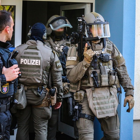 Polizisten durchsuchen eine Wohnung in Bergen-Enkheim. 