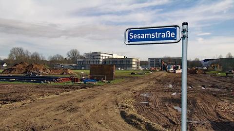 "Sesamstraße" steht auf einem Straßenschild, dahinter eine Baustelle.