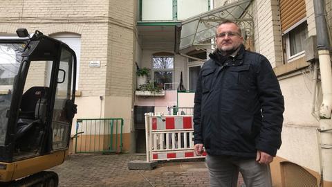 Ein Mann steht vor einer Baustelle im Innenhof eines Hauses.