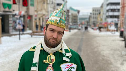 Ein Fuldaer Karnevalist steht traurig auf der Straße, weil der Rosenmontagszug wegen Corona abgesagt wurde.