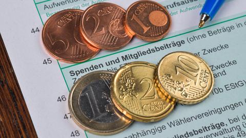 Geldstücke liegen im Bereich "Spenden und Mitgliedsbeiträge" auf einer Steuererklärung 