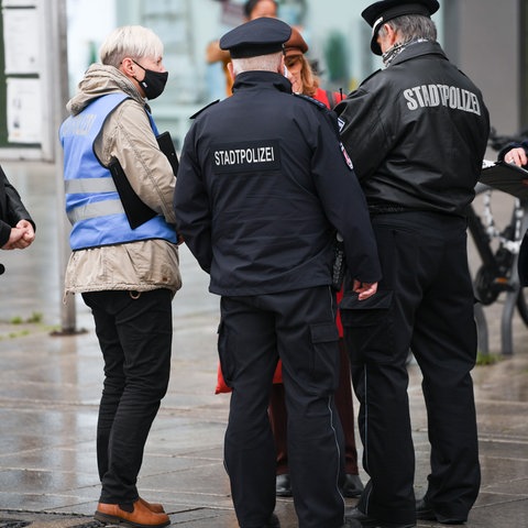 Frankfurter Stadtpolizisten kontrollieren eine Passantin.
