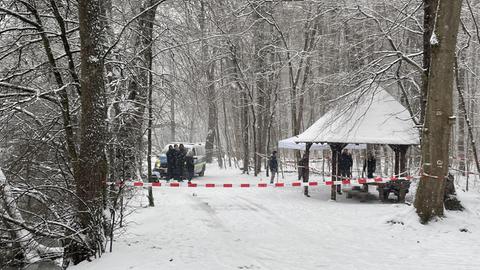 Mitarbeiter der Polizei an einem abgesperrten Unterstand im verschneiten Frankfurter Stadtwald.