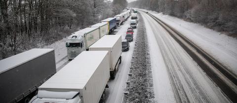 Lastwagen stauen sich auf einer Autobahn im Schnee