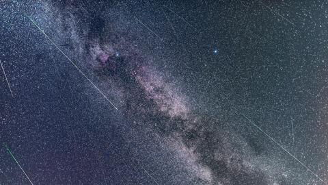 Ein Bild des Nachthimmels, bei dem unzählige Sterne und Sternschnuppen zu sehen sind.