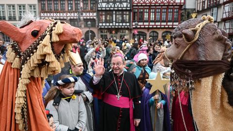 Kinder mit Kronen, als Kamele Verkleidete, in der Mitte Bischof