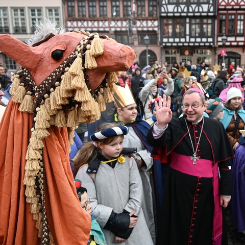 Kinder mit Kronen, als Kamele Verkleidete, in der Mitte Bischof