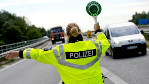 Polizistin mit Schild auf Autobahn: "Straße frei"