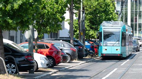 Straßenbahn fährt an parkenden Autos in der Schwarzwaldstraße in Frankfurt-Niederrad entlang