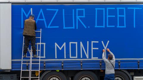 Streikende LKW-Fahrer bekleben die Außenplane eines Fahrzeuges "Mazur Debtor - No Money", um auf ihre Situation aufmerksam zu machen. 